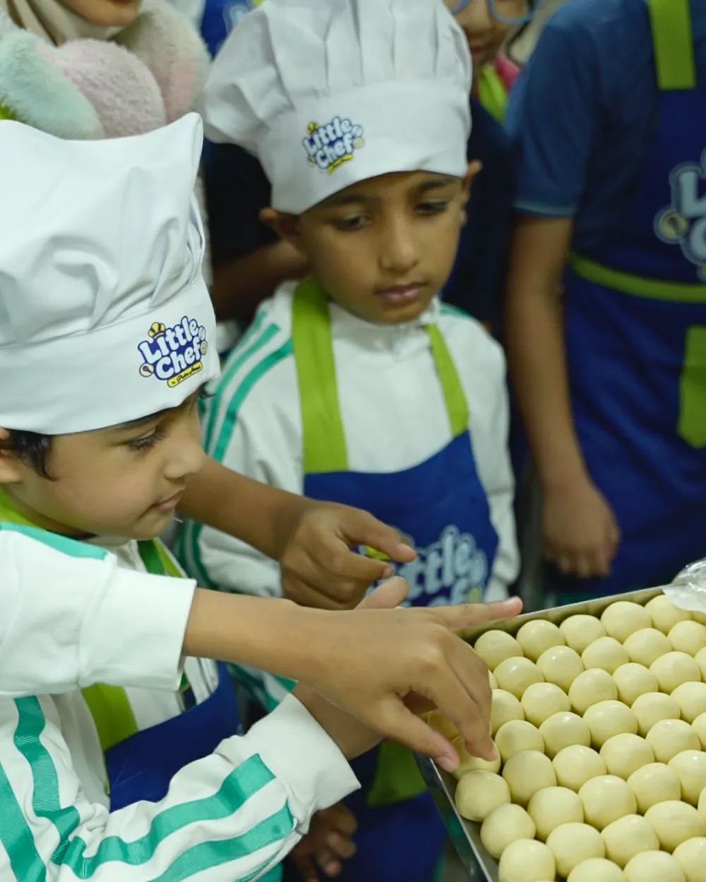 Children shaping biscuit dough on a tray