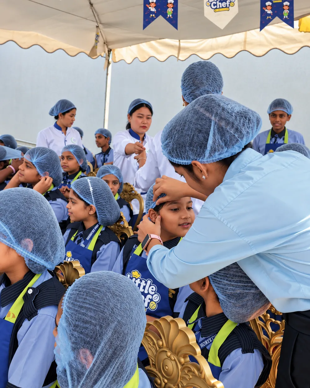 A team member helping a child put on a hairnet